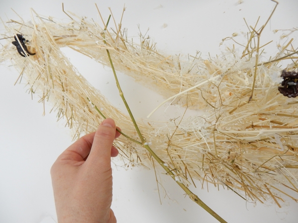 Peg a few dried stems into the armature to secure the shape Peg a few dried stems into the armature to secure the shape
