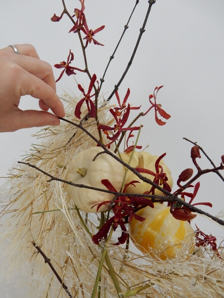 Place the orchids in the water and add twigs and autumn leaves Place the orchids in the water and add twigs and autumn leaves