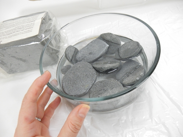 Carve pebbles out of floral foam and soak in water until the foam sinks to the bottom of the container Carve pebbles out of floral foam and soak in water until the foam sinks to the bottom of the container