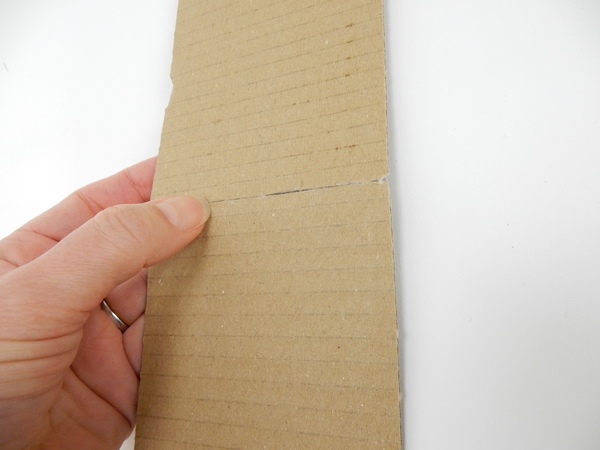 Glue the strips of cardboard to create a long strip that can go around the cardboard circle Glue the strips of cardboard to create a long strip that can go around the cardboard circle