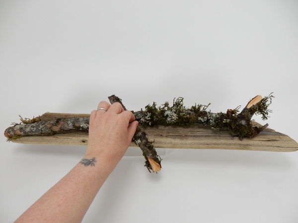 Place moss covered sticks on the driftwood Place moss covered sticks on the driftwood
