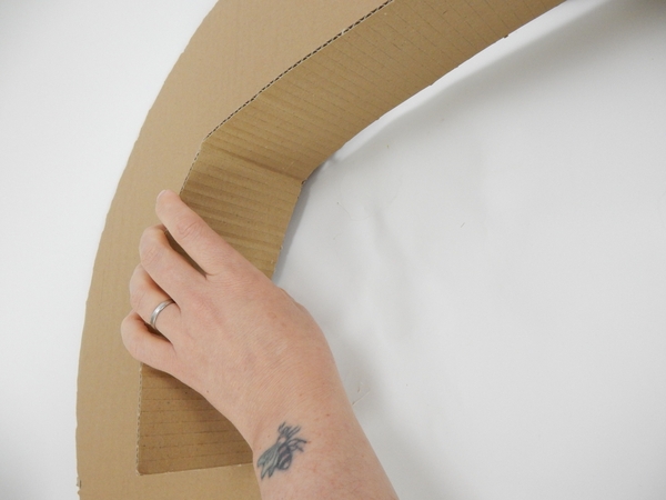Start to glue the strips to the inside edge of the cardboard wreath shape Start to glue the strips to the inside edge of the cardboard wreath shape