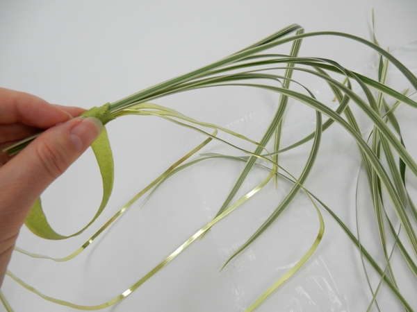 Bind a small bundle of grass to the one side of the basket handle letting the tips dangle down the side Bind a small bundle of grass to the one side of the basket handle letting the tips dangle down the side