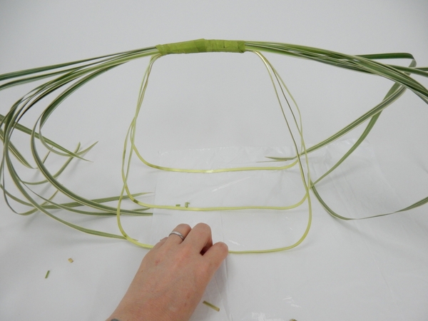 Bind another small bundle of grass facing the other way. Bind another small bundle of grass facing the other way.
