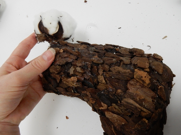 Glue a few cotton pods around the edge of the bark Christmas stocking Glue a few cotton pods around the edge of the bark Christmas stocking