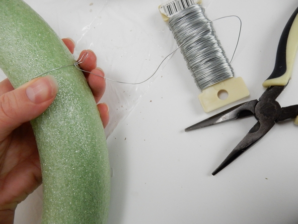 Wrap silver wire around a foam wreath frame and add a loop to make it easier to hang the wreath