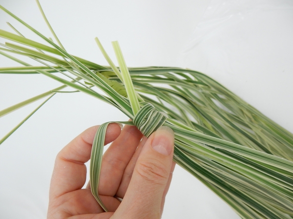 Wrap the stems with a blade of grass to create a neat handle Wrap the stems with a blade of grass to create a neat handle