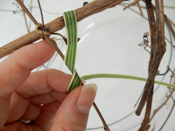 Wrap the grass around a stem close to the first one Wrap the grass around a stem close to the first one