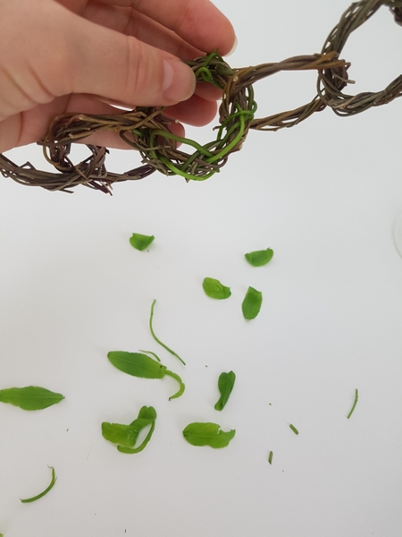Continue adding green stems to the wreath Continue adding green stems to the wreath