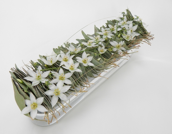 Eucomis and Eucalyptus and grass in a glass container