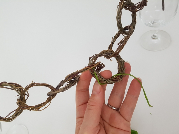 Press the stem end into a gap in the wreath Press the stem end into a gap in the wreath