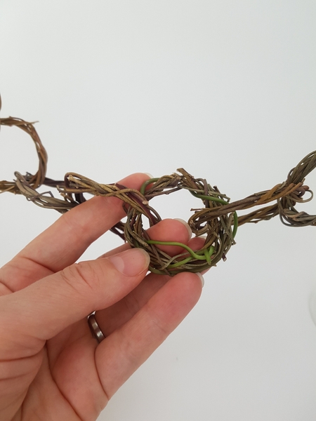 Wrap the stem around and through any gaps in the wreath Wrap the stem around and through any gaps in the wreath