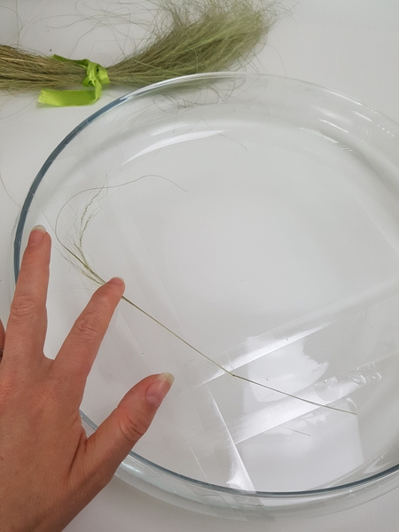 Set a blade of grass to follow the wreath shape on the tape Set a blade of grass to follow the wreath shape on the tape