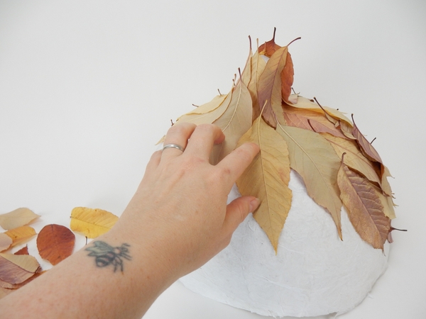 Add leaves down and around the paper shape Add leaves down and around the paper shape