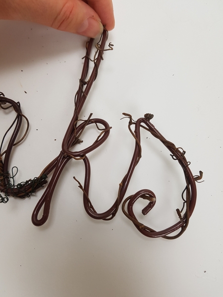 Carefully open a few vine tendrils and curl it around the letters Carefully open a few vine tendrils and curl it around the letters