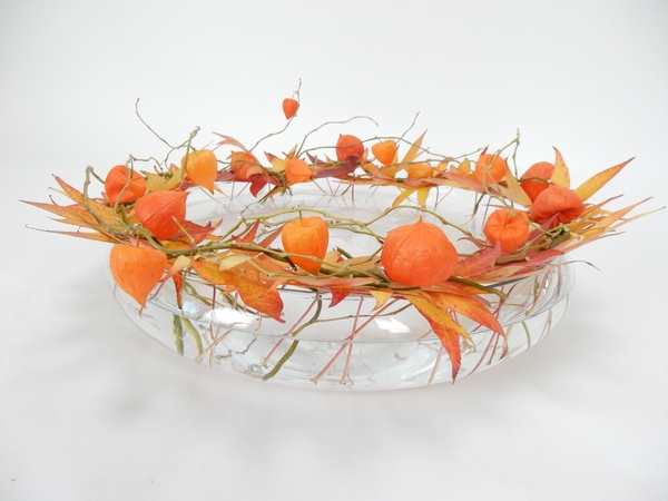 Fall leaves, Physalis and willow stacked around the edge of a container