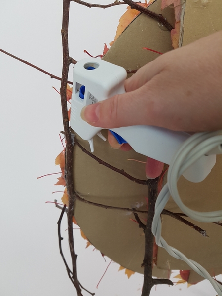 Glue the twigs to the cardboard at the back Glue the twigs to the cardboard at the back