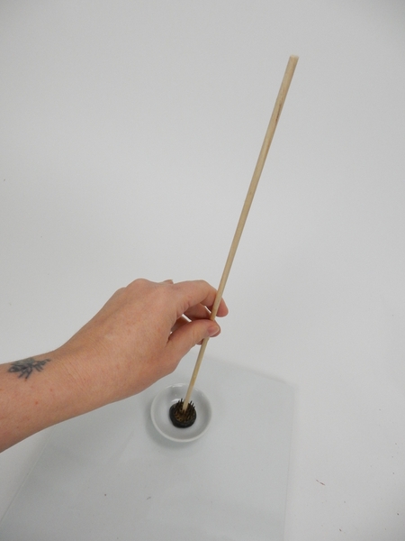 Place a dowel in a small container Place a dowel in a small container