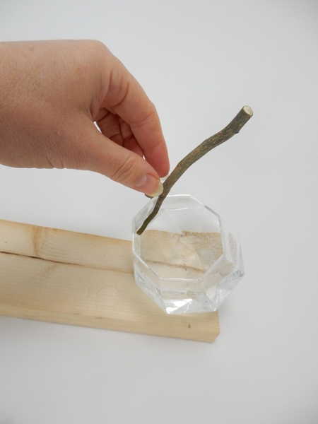 Cut a twig, with a fork in it, to fit over the edge of the vase Cut a twig, with a fork in it, to fit over the edge of the vase