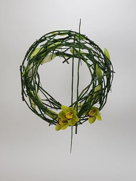 Lily, Cymbidium and wired Equisetum wreath flower arrangement