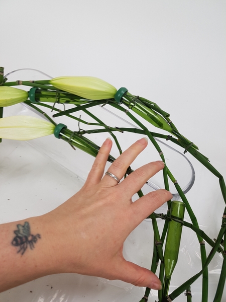 Twist the wreath so that you can fill and position the next water tube and lily Twist the wreath so that you can fill and position the next water tube and lily