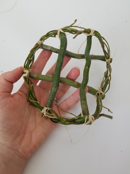Tie four twigs across the bottom of one wreath Tie four twigs across the bottom of one wreath