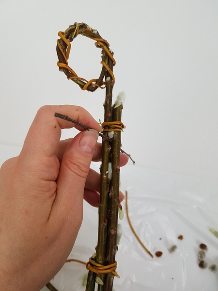Push the first horizontal stem through the twig bundle Push the first horizontal stem through the twig bundle