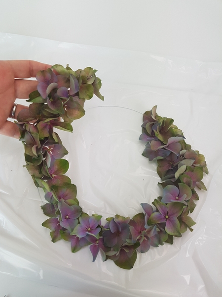 Lift the hydrangea wreath and gently wiggle it. Glue down any florets that are not secure. Lift the hydrangea wreath and gently wiggle it. Glue down any florets that are not secure.