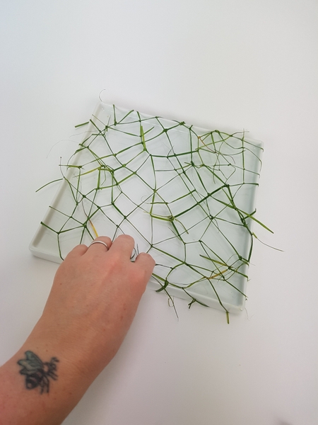 Cover the entire container surface with knotted ripped grass strips. Cover the entire container surface with knotted ripped grass strips.