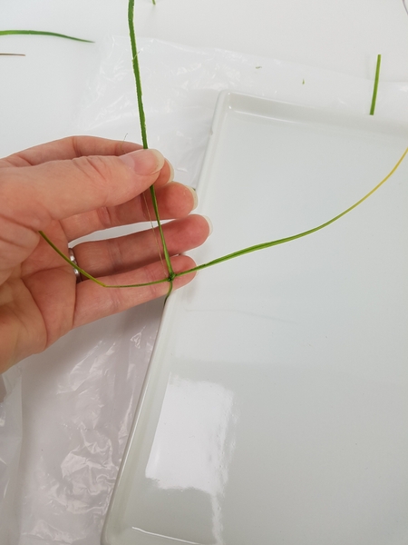 Fold the ripped grass over to the front and start knotting in grass strips. Fold the ripped grass over to the front and start knotting in grass strips.