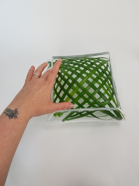 Position the woven grass to be in the center of the container. Position the woven grass to be in the center of the container.