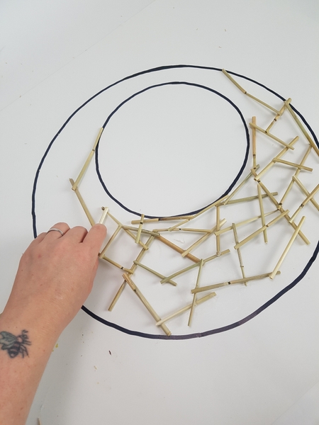Glue the grass snippets in a random pattern all around the wreath Glue the grass snippets in a random pattern all around the wreath