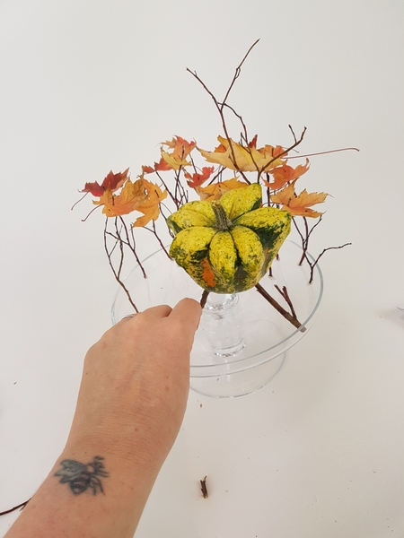 Add legs to a small pumpkin and add it to the design to hover at the same height as the leaves Add legs to a small pumpkin and add it to the design to hover at the same height as the leaves