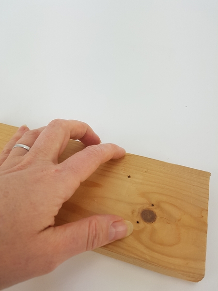 Drill a small hole in a piece of lumber Drill a small hole in a piece of lumber