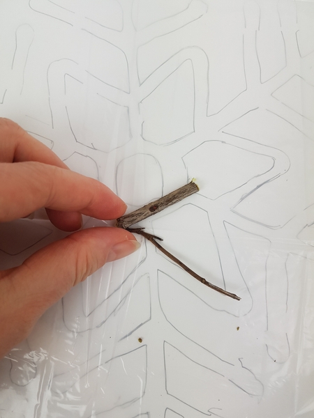 Cut twigs into small snippets to glue in the shape of the snowflake Cut twigs into small snippets to glue in the shape of the snowflake