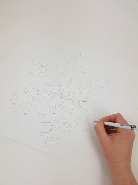 Draw the snowflake pattern on a large cardboard
