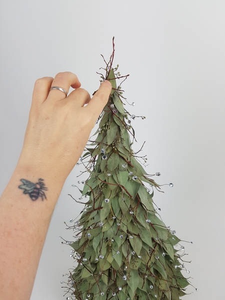 Finish the design by adding a few winter twigs to break up the roof tile pattern of the leaves Finish the design by adding a few winter twigs to break up the roof tile pattern of the leaves