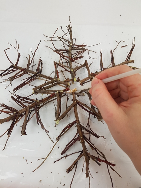 Paint the twig snowflake with thinned wood glue Paint the twig snowflake with thinned wood glue