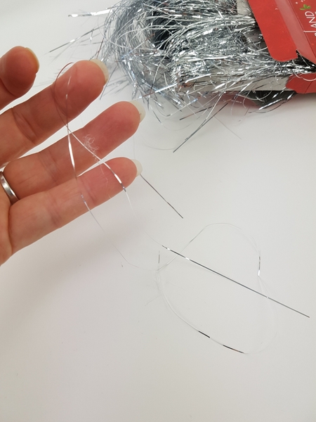 Pull a single strand from the tinsel container. Pull a single strand from the tinsel container.