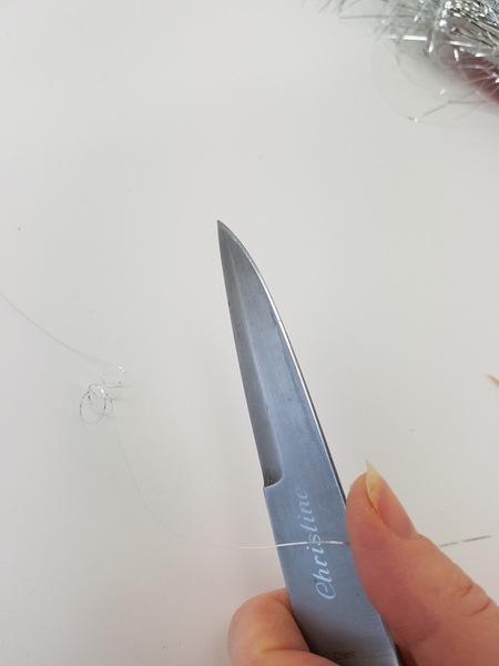 Pull the tinsel over a blade to curl Pull the tinsel over a blade to curl
