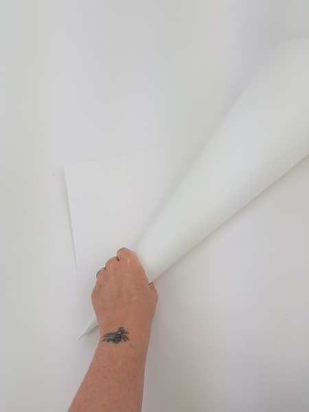 Roll a large sheet of thin cardboard into a sharp cone shape Roll a large sheet of thin cardboard into a sharp cone shape