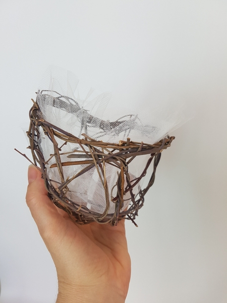 Fluff the tulle open to create a hollow opening for the basket and secure if needed Fluff the tulle open to create a hollow opening for the basket and secure if needed