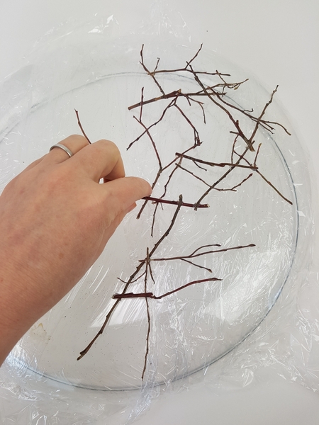 Glue the twigs to over the container. Glue the twigs to over the container.