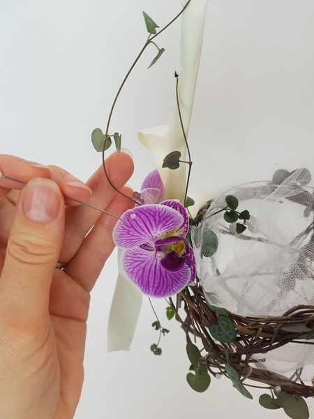 Place fresh flowers in small water tubes to keep them hydrated and add tiny pearls to the design. Place fresh flowers in small water tubes to keep them hydrated and add tiny pearls to the design.