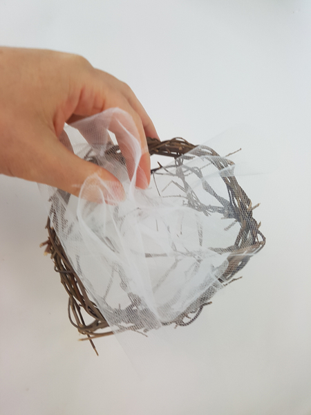 Tuck the tulle into the basket so that it extends slightly over the edge