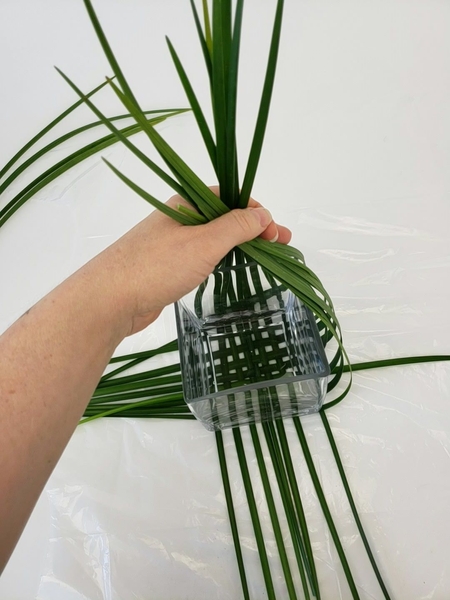 Fold the grass up over the container Fold the grass up over the container