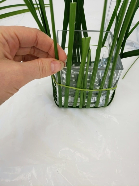 Slip an elastic band over the grass to keep it in place Slip an elastic band over the grass to keep it in place