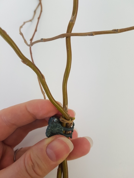 Wind the willow stem around the first two stems Wind the willow stem around the first two stems