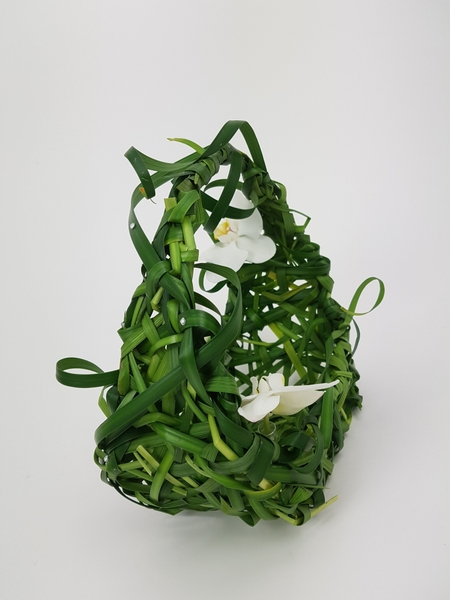Floral arrangement of woven grass and orchids Floral arrangement of woven grass and orchids