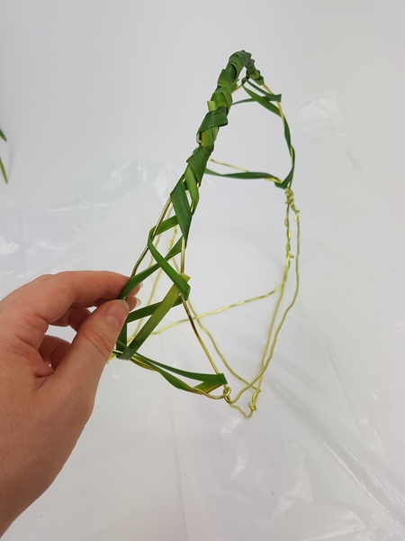 Wrap the grass around the sides of the basket leaving wide gaps Wrap the grass around the sides of the basket leaving wide gaps
